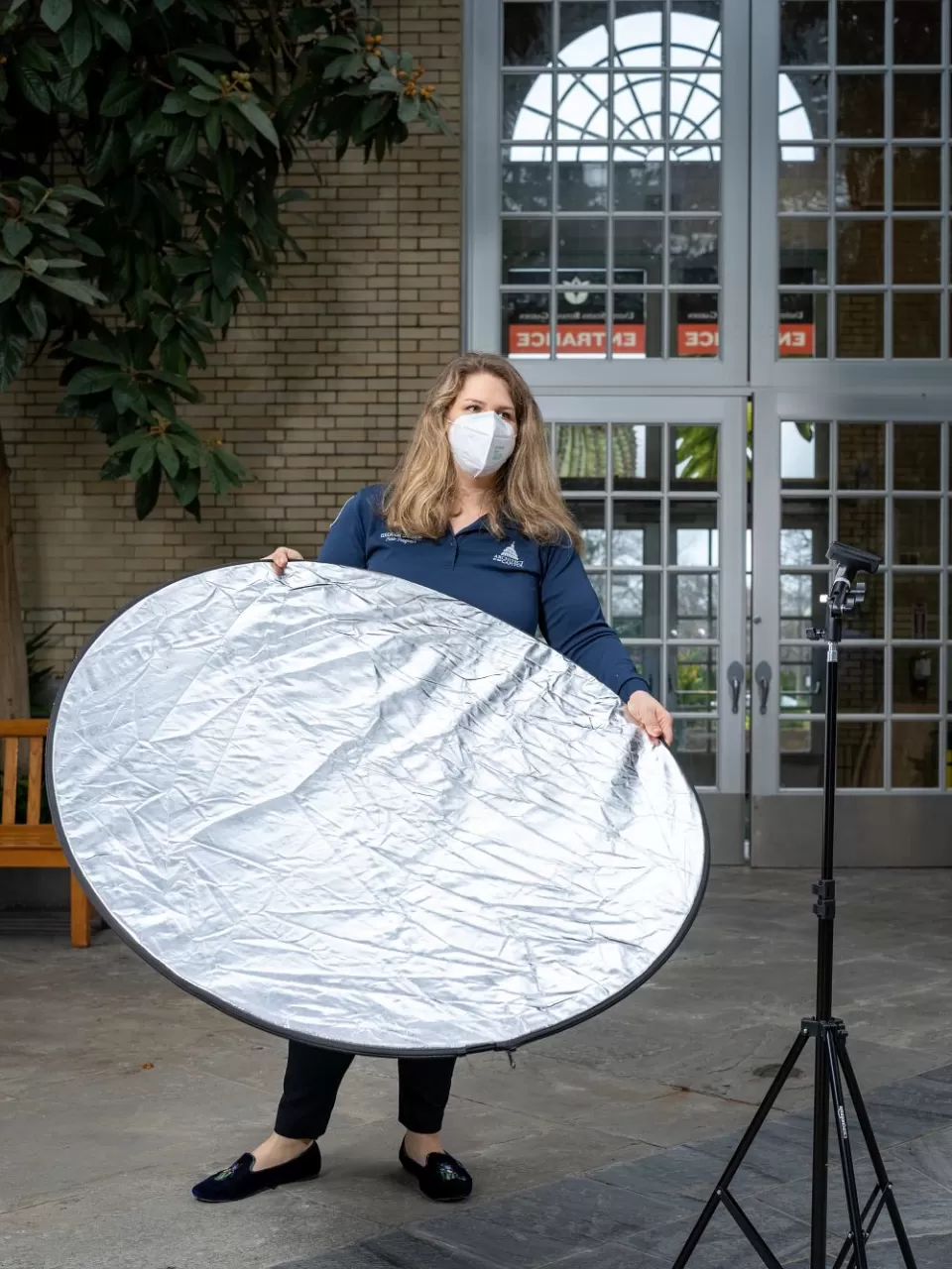 Anderson tests how additional lighting from a reflector might help the presentation be better visible on-screen.