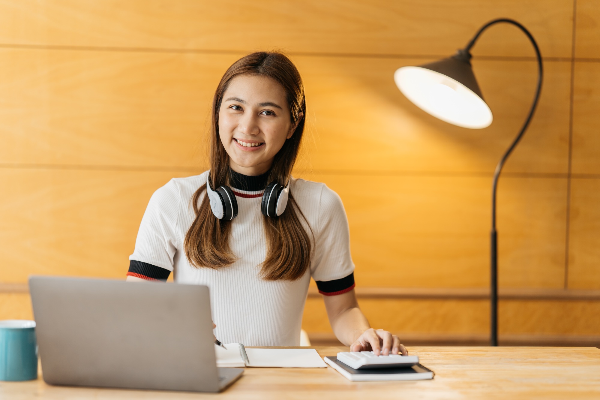 young attractive asian female employee wear earphone listen to digital online course development