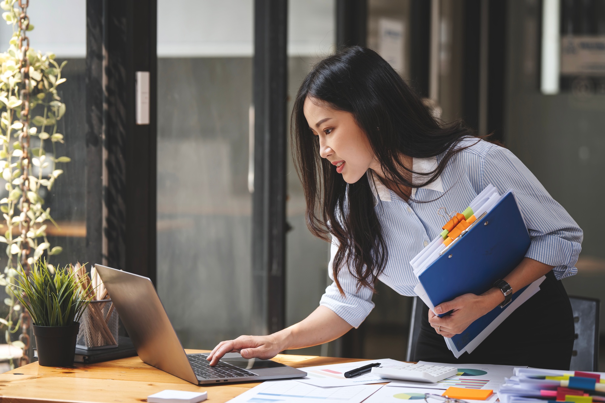 young businesswoman working with documents in office, checking financial report